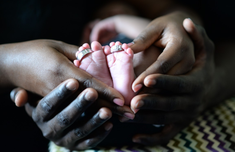 parents holding a baby